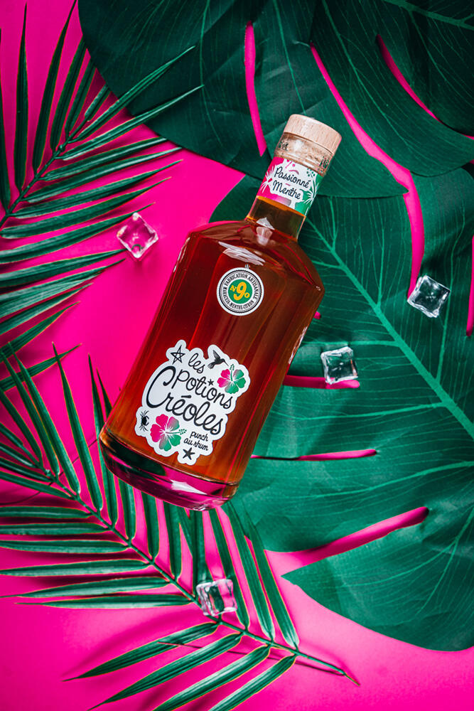 photos produits photographe culinaire les potions creoles bouteille les potions créoles sur fond rose et feuilles