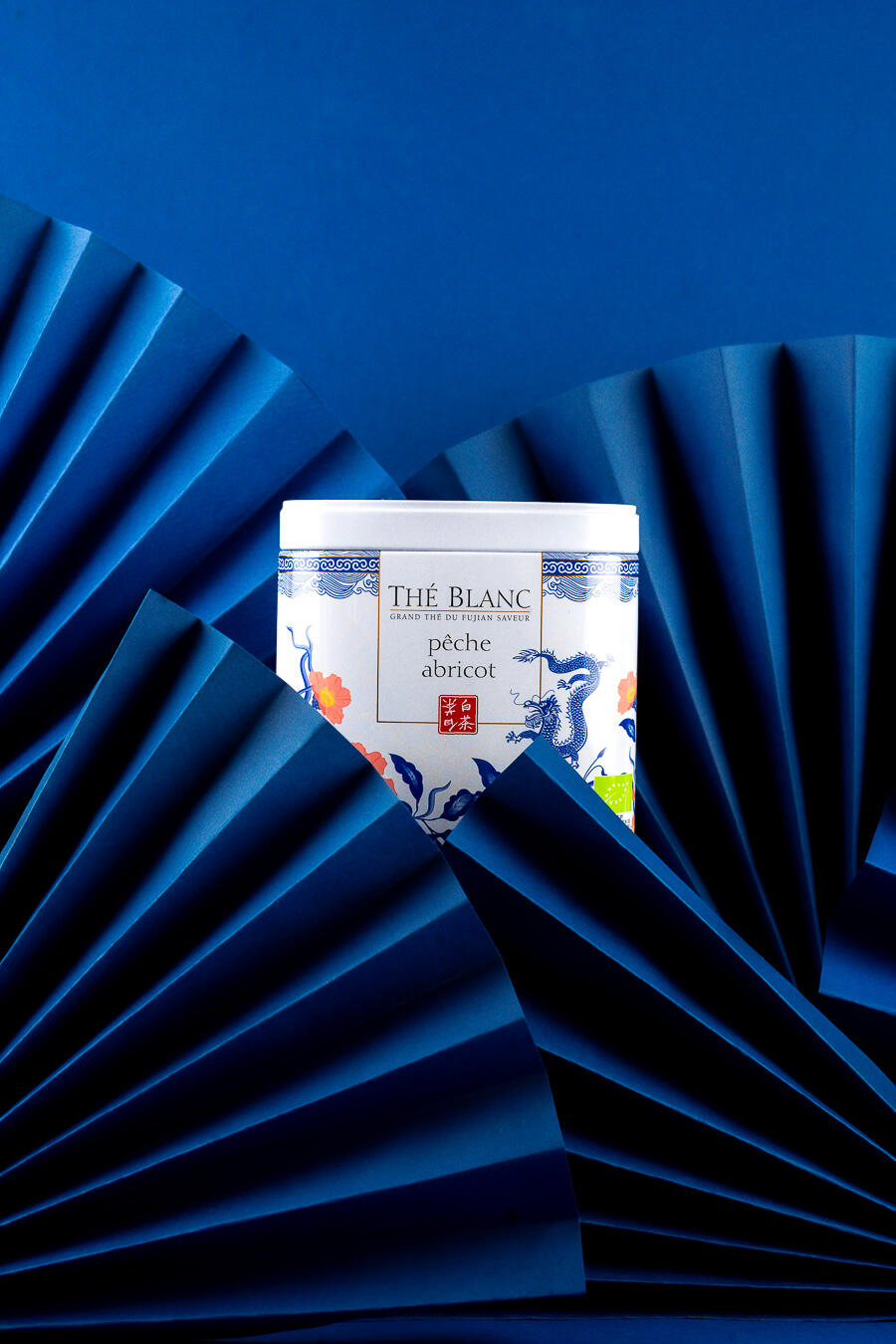 photo produit culinaire région centre photo d'une boite de thé peche abricot entourée d'éventails bleus